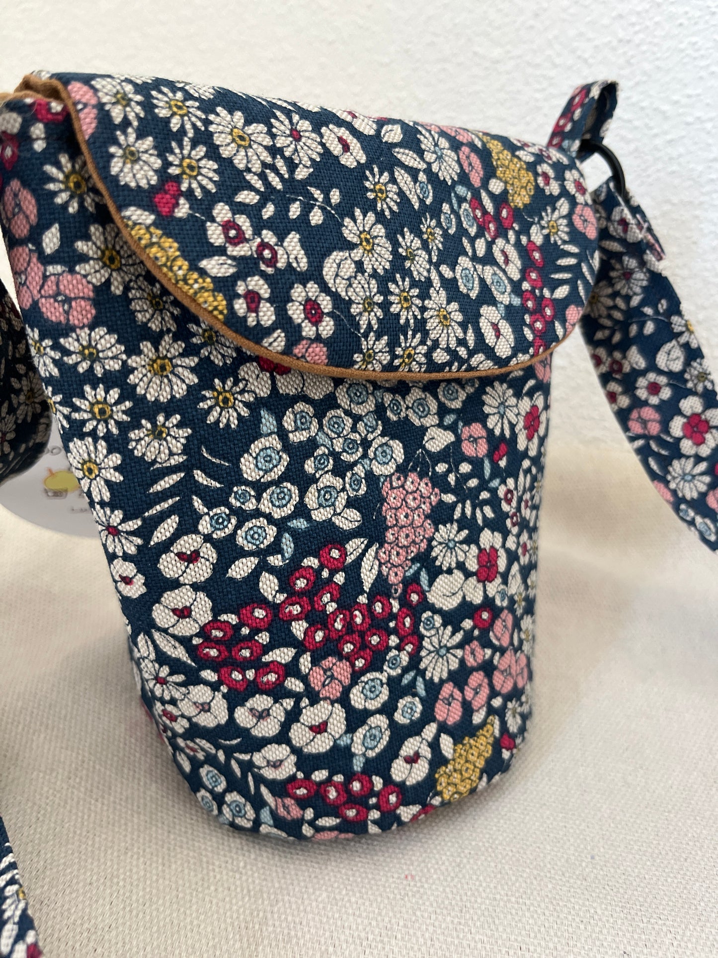 Schultertasche mit Blumen auf blauem Hintergrund