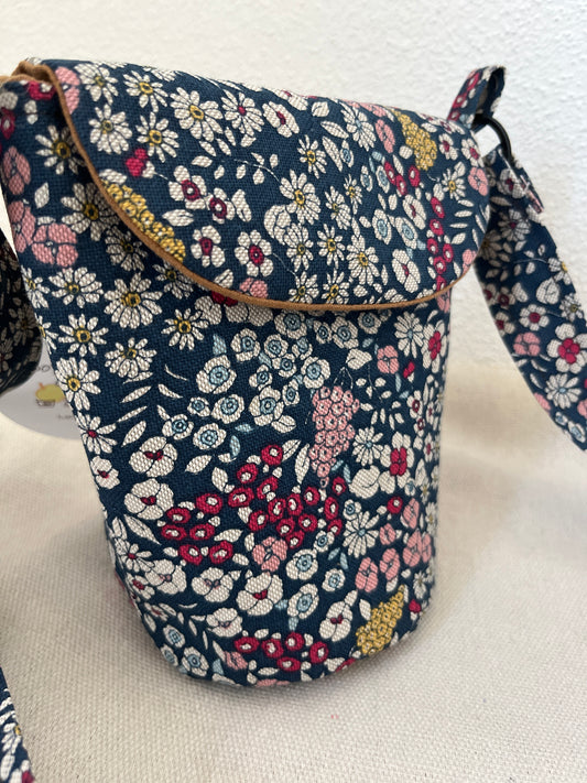 Schultertasche mit Blumen auf blauem Hintergrund