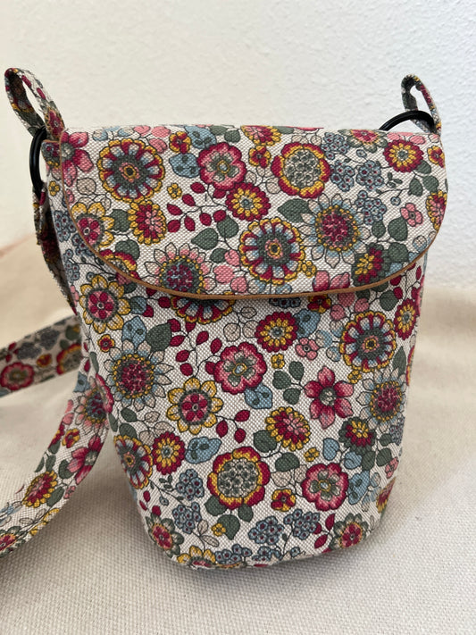 Schultertasche mit Blumen auf hellem Hintergrund