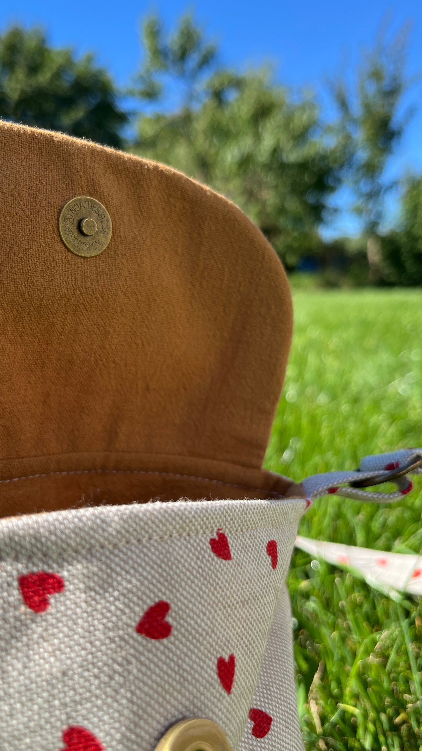 Schultertasche mit Herzmuster auf Beige Hintergrund