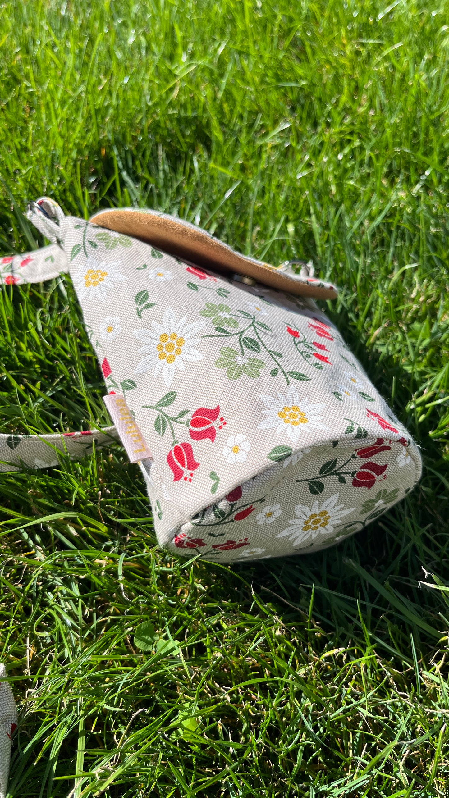Schultertasche mit Blumen auf Beige Hintergrund