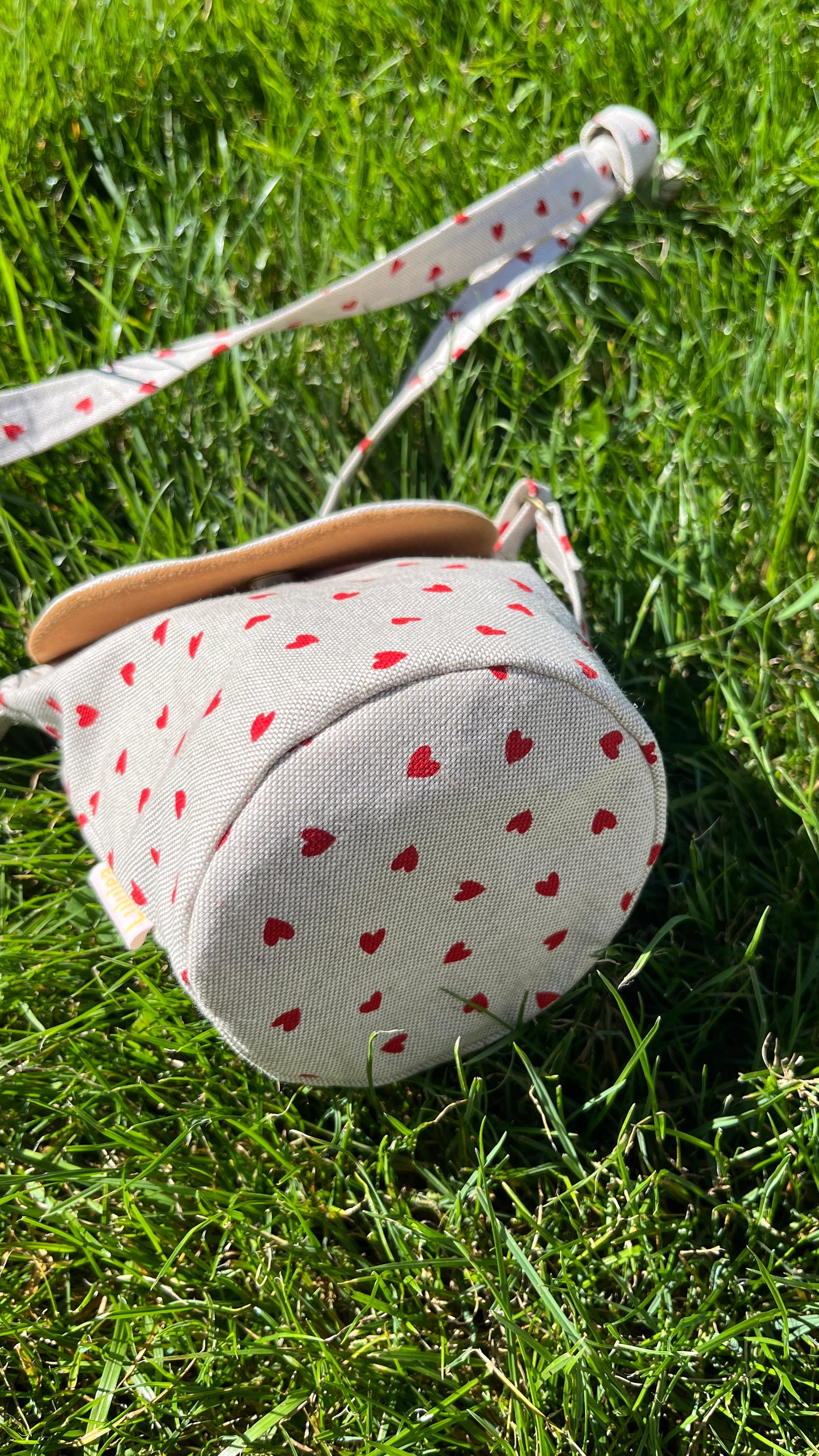 Schultertasche mit Herzmuster auf Beige Hintergrund