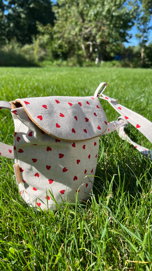 Schultertasche mit Herzmuster auf Beige Hintergrund